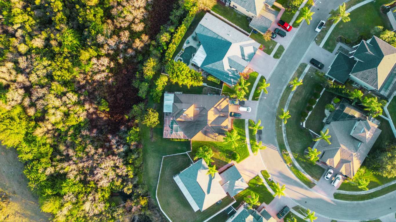Aerial view of a sunny residential neighborhood surrounded by lush greenery—perfect for families moving to Southwest Florida seeking comfort and natural beauty.